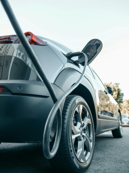 Electric car connected to a portable EV charger during charging process.